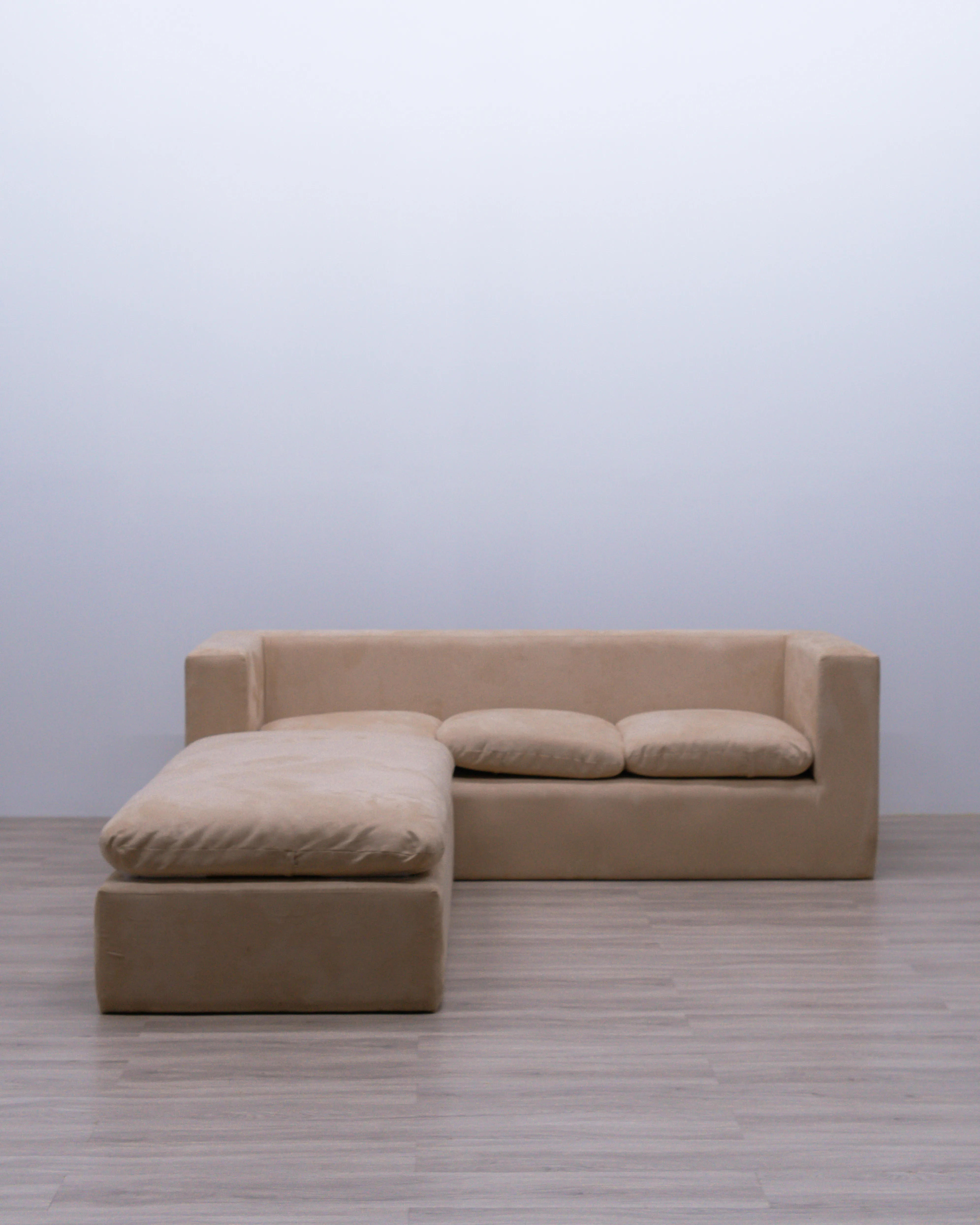 Luxury Serena Hug L-shaped sectional sofa featuring a natural certified teak wood frame, soft suede upholstery with Royal Foam cushioning, designed in a modern minimalist style.